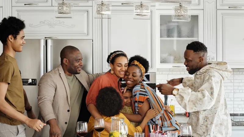 Family hugging and smiling together in their kitchen