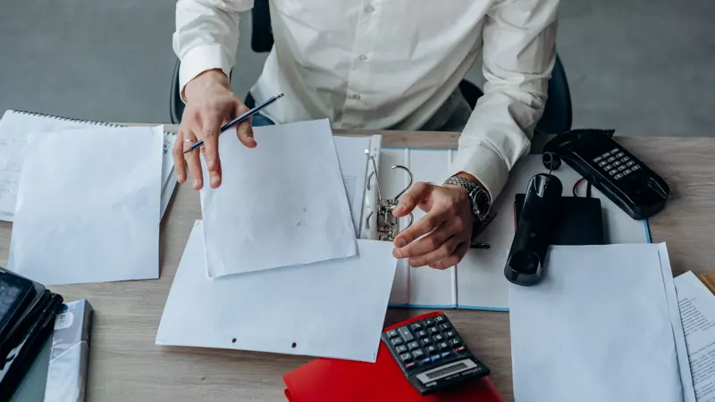Person going over paperwork and documents at a desk before applying